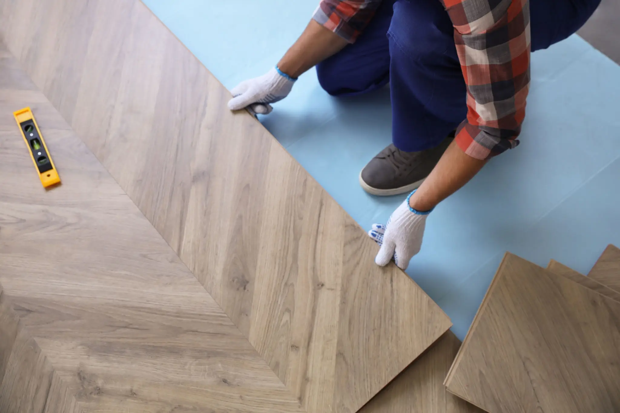 Hands placing herringbone pattern flooring
